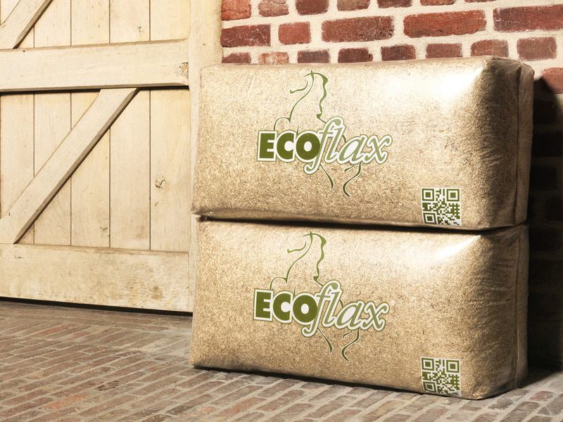 Zwei Ballen Ecoflax Leinenstroh vor einem Stalltor